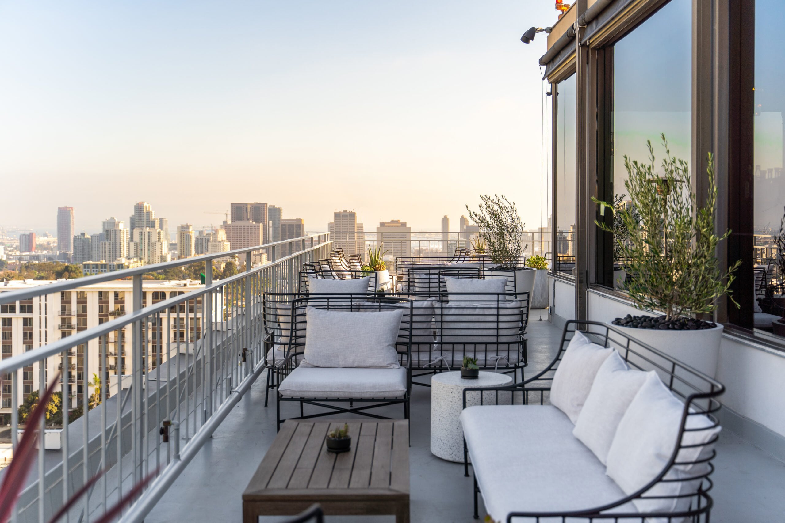Lounge seating on the East Patio at Mister A's at golden hour with downtown San Diego views