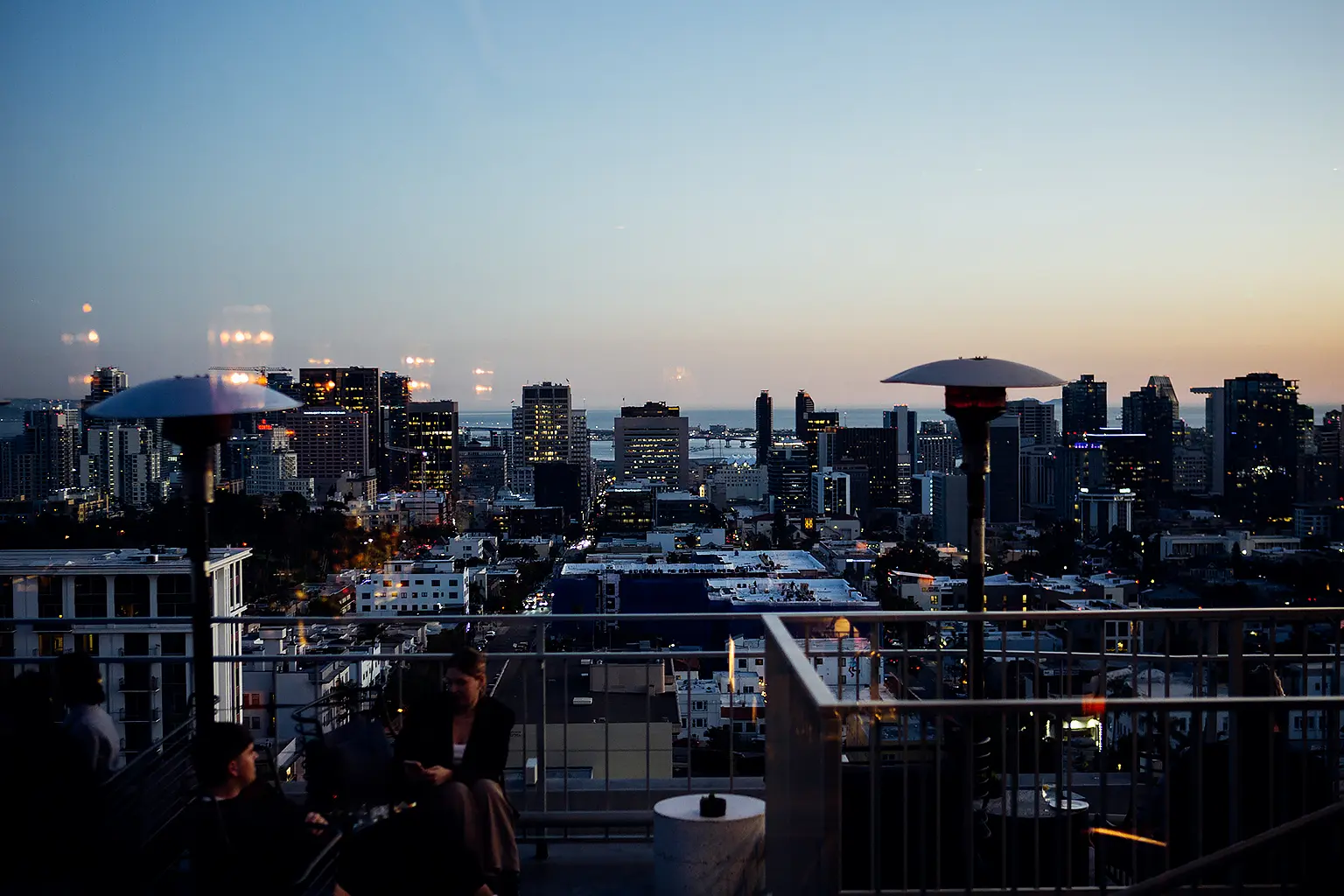 The East Patio at Mister A's at dusk with patio heaters and the downtown San Diego skyline